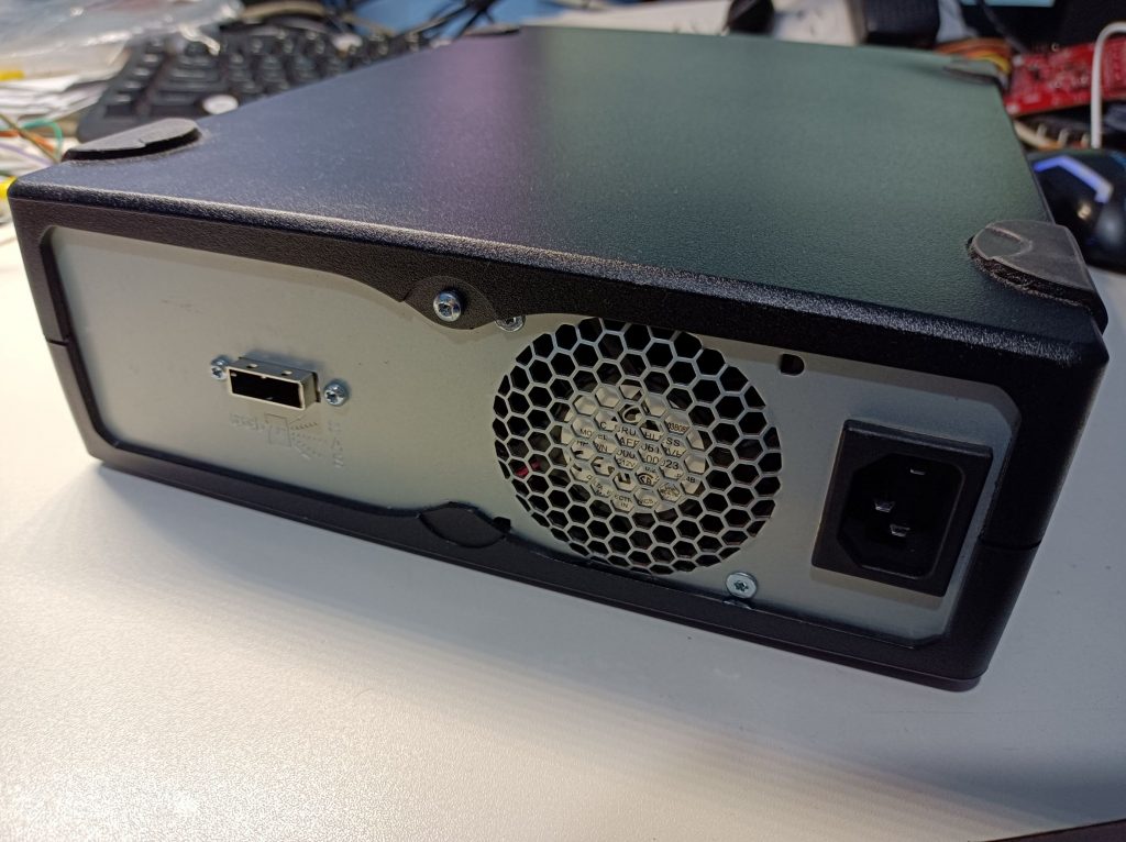 Photo showing the back panel of the tape drive with a SAS port and a IEC power port.