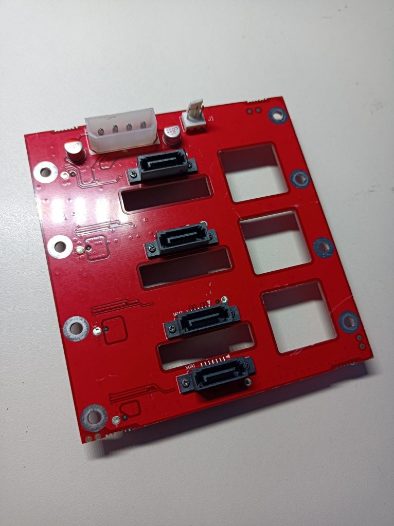 Back of the NAS backplane PCB, showing 4 SATA ports, a standard 4-pin Molex power connector and a 3-pin header for a cooling fan.